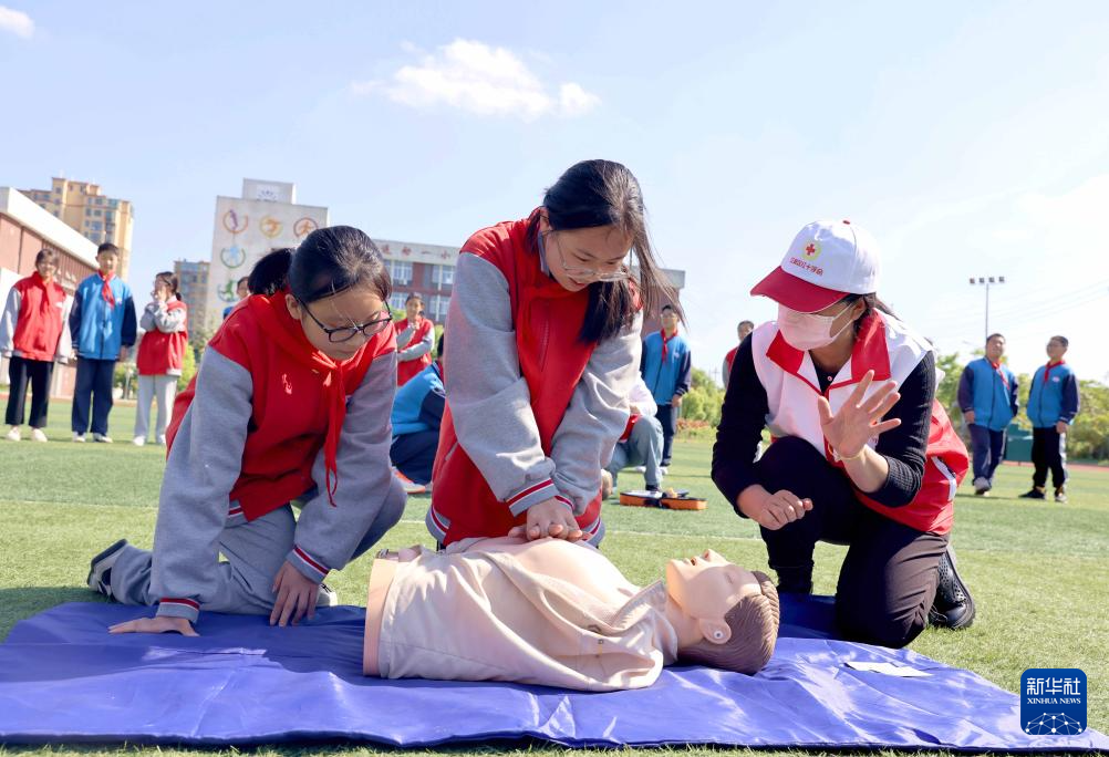5月8日,江苏省扬州市江都区第二中学学生在红十字会工作人员的指导下